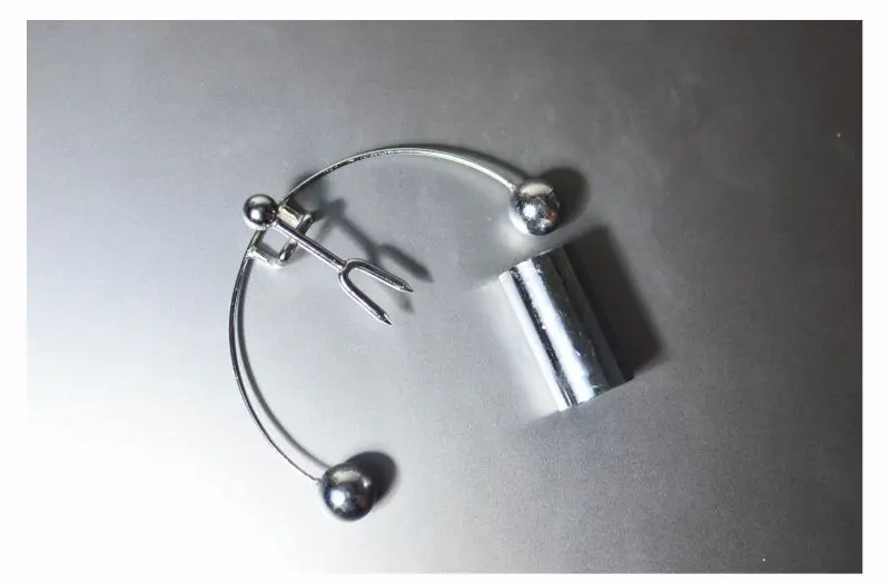 Polished Metal Accessory on a Gray Surface Silver metal circular object with spherical ends,
a forked piece, and a cylindrical attachment